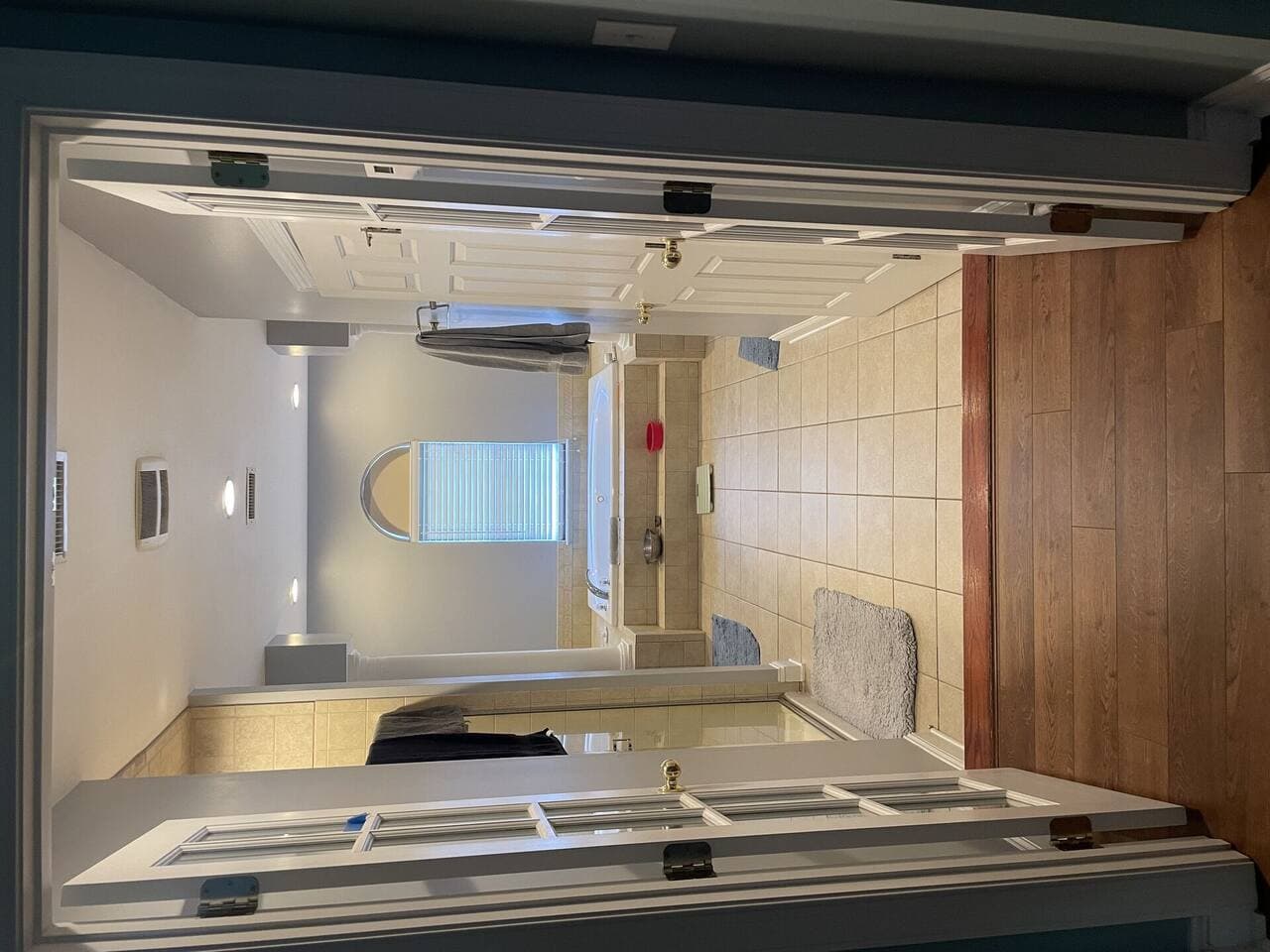 Outdated primary bathroom with builder-grade vanity prior to renovation