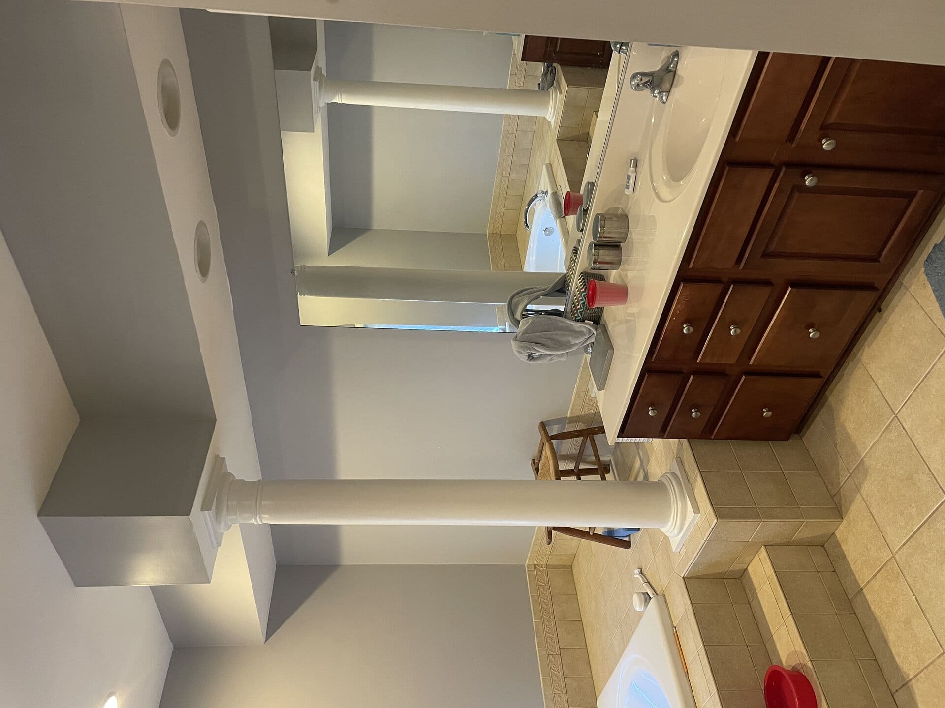 Wide view of the bathroom showing limited storage and yellow lighting before work began