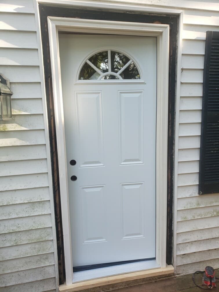 Exterior door replacement in Charlotte, NC — new white entry door with fan-lite window installed