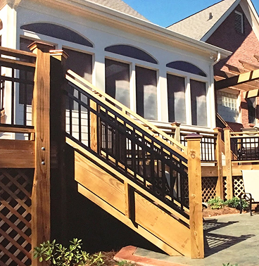 A wooden staircase leads up from a patio to a porch