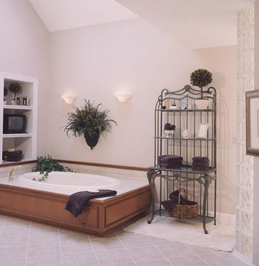 A bathroom with a shallow, low-to-the-ground white bathtub inside of a square wooden frame
