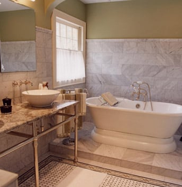A bathroom with a white bathtub situated next to the window
